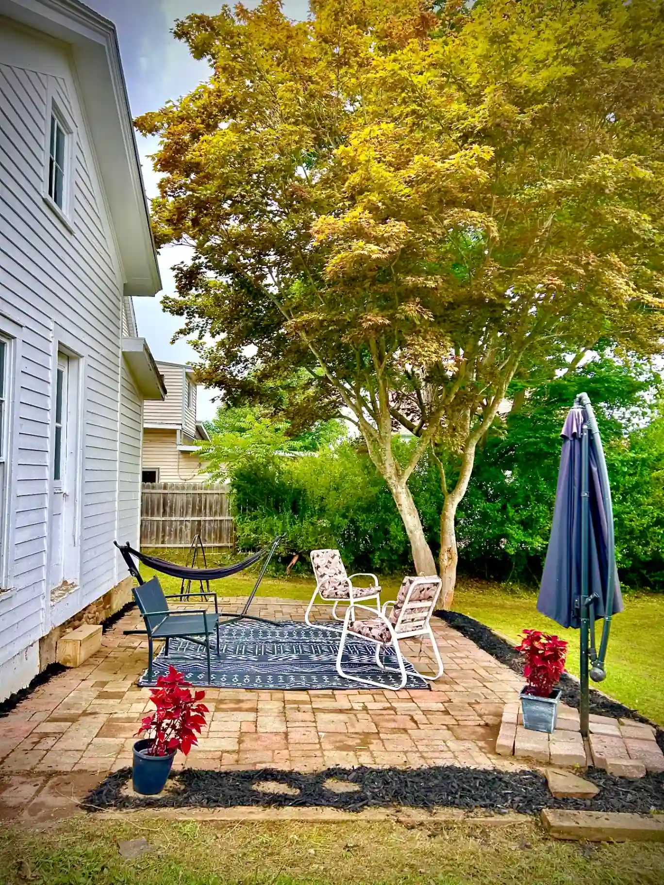 After patio transformation - clean patio with fresh mulch, furniture, and plants